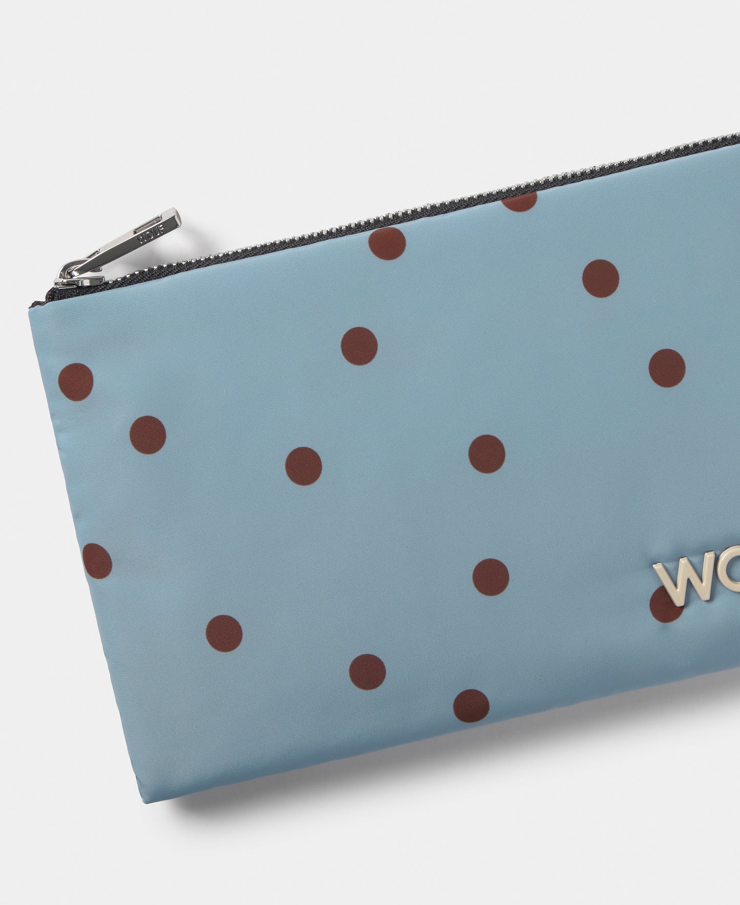Detalle del pouch con lunares marrones sobre fondo azul claro - Wouf