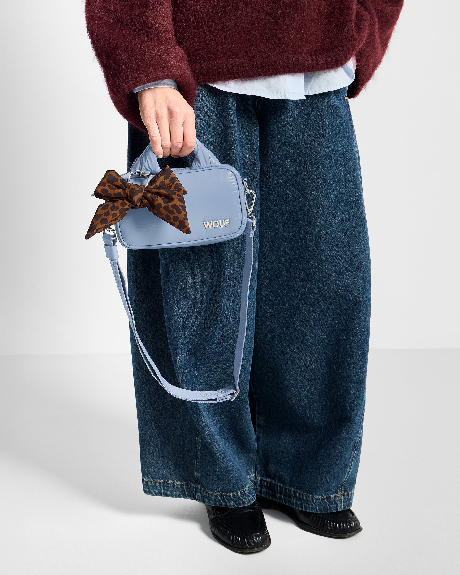 Detail of model with bow-shaped bag charm with leopard print in brown and black tones - Wouf