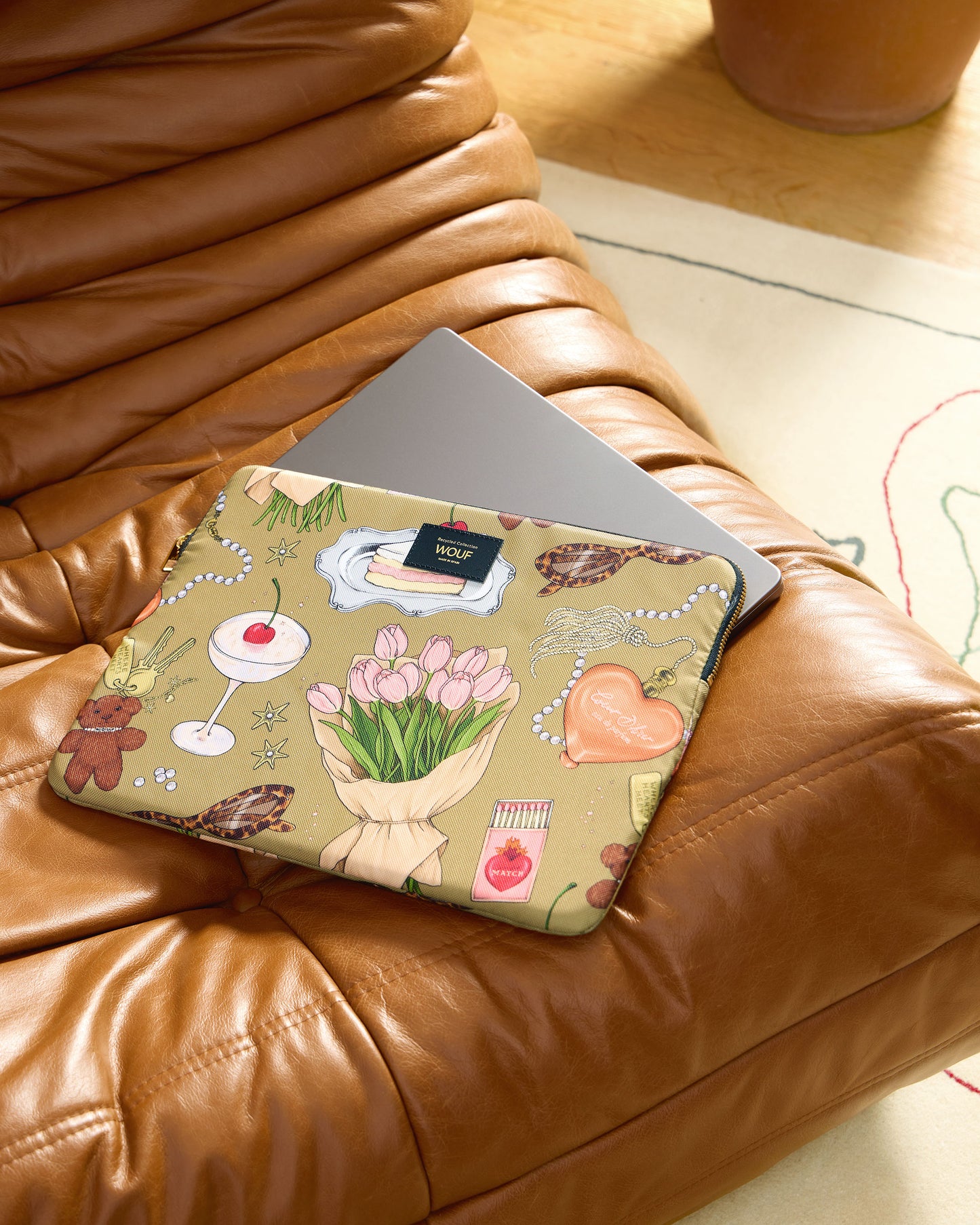 Lifestyle image of the Tender 13-14 laptop sleeve with multicolour illustrated print on a khaki background - Wouf