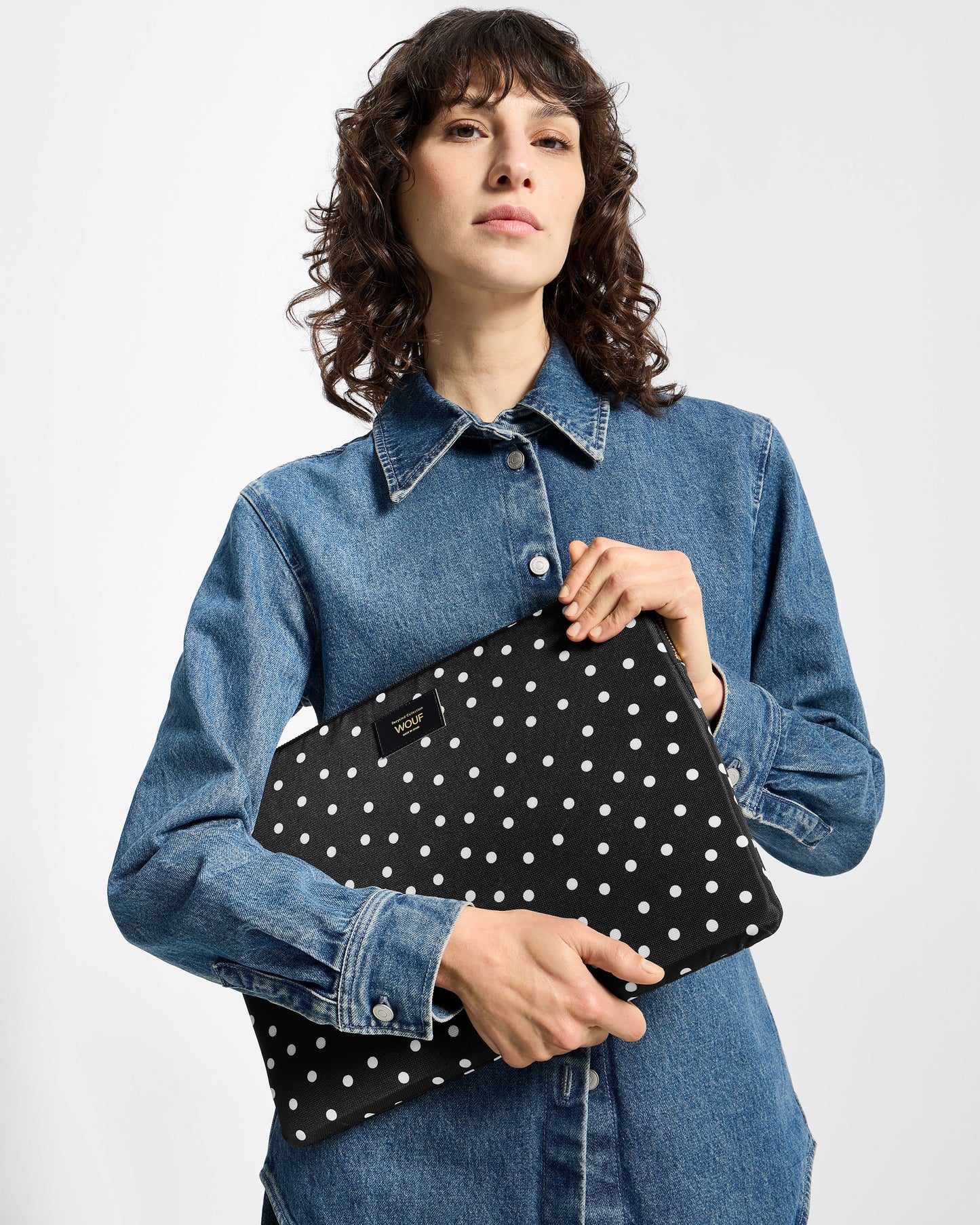 Model with 13-14-inch laptop sleeve with white polka dot print on a black background - Wouf