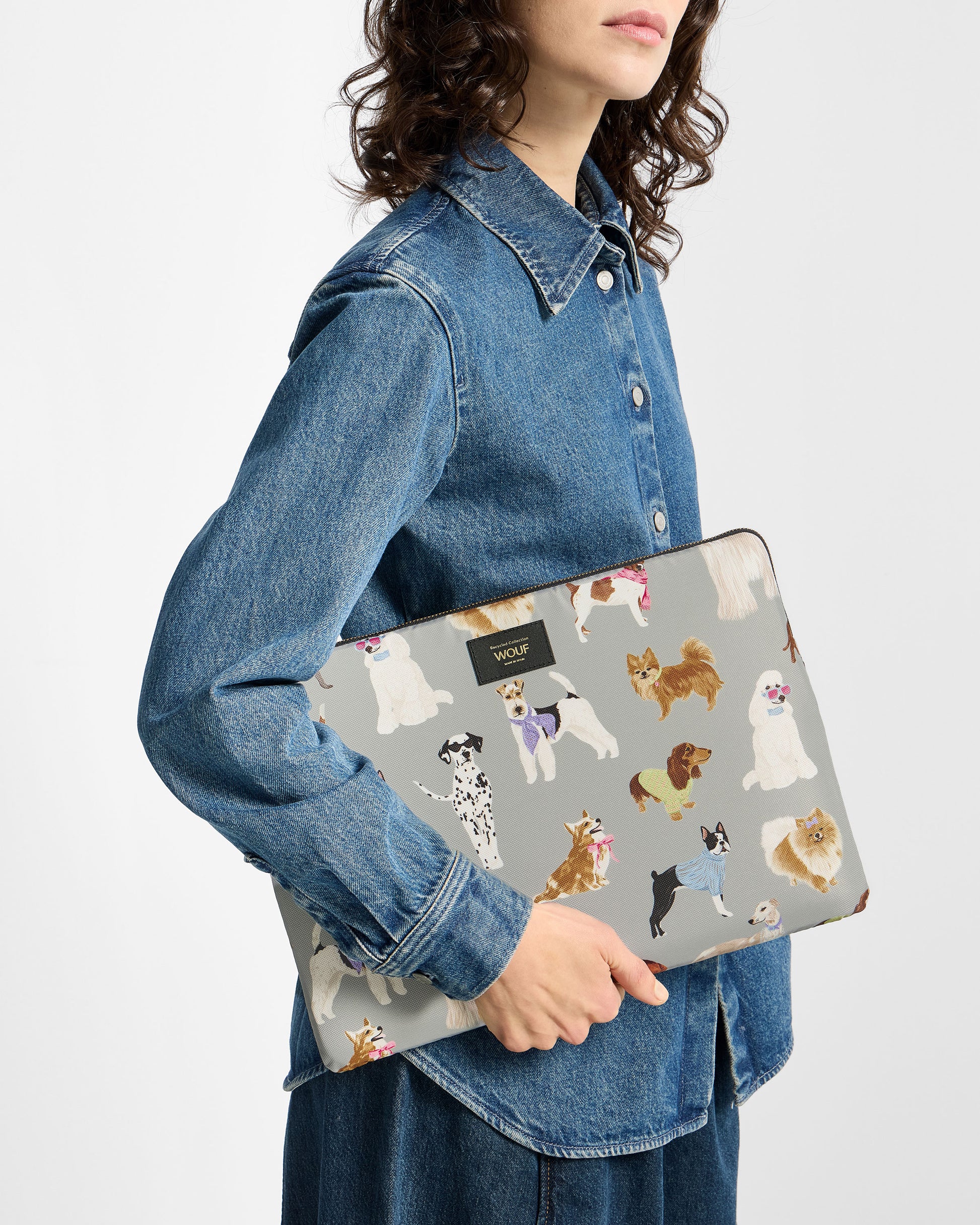 Model with 13-14-inch laptop sleeve with multicolour dog print on a grey background - Wouf