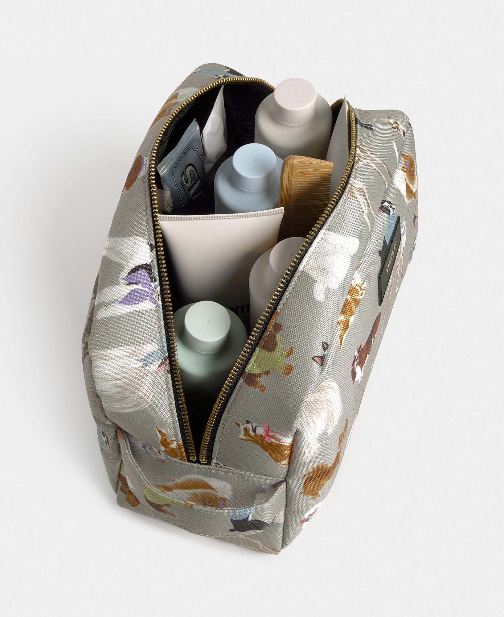Interior detail of the Puppy large toiletry bag with multicolour dog print on a grey background - Wouf