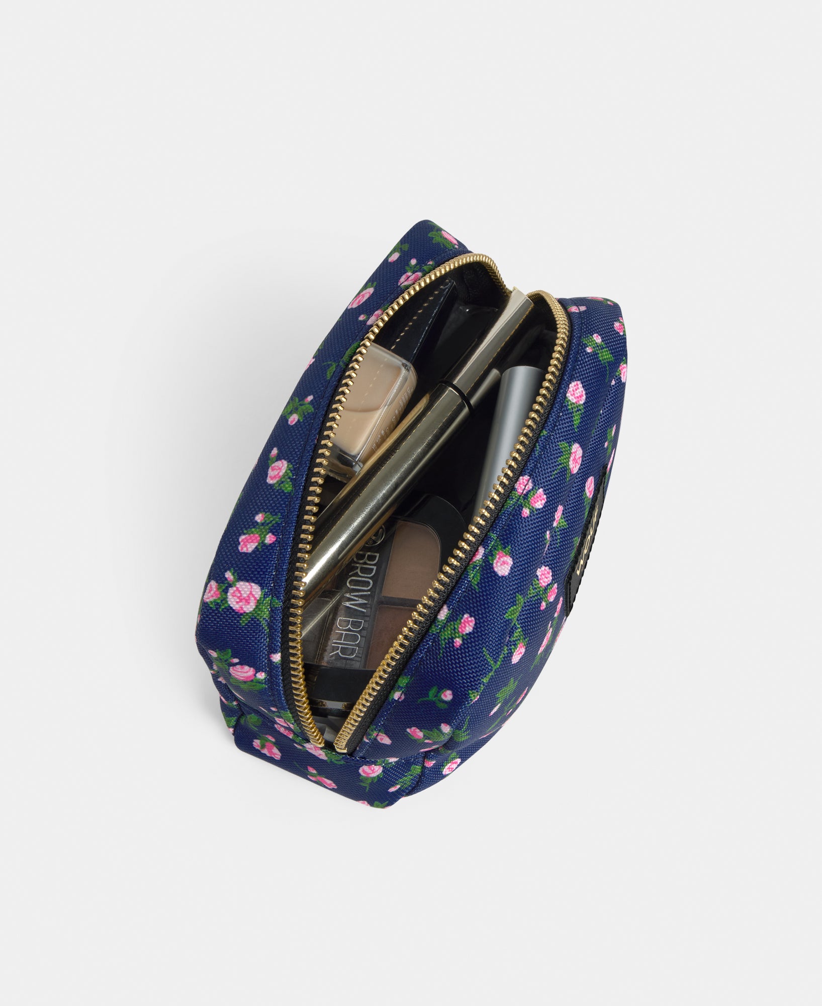 Interior detail of the Edith makeup bag with pink and green floral print on a navy background - Wouf