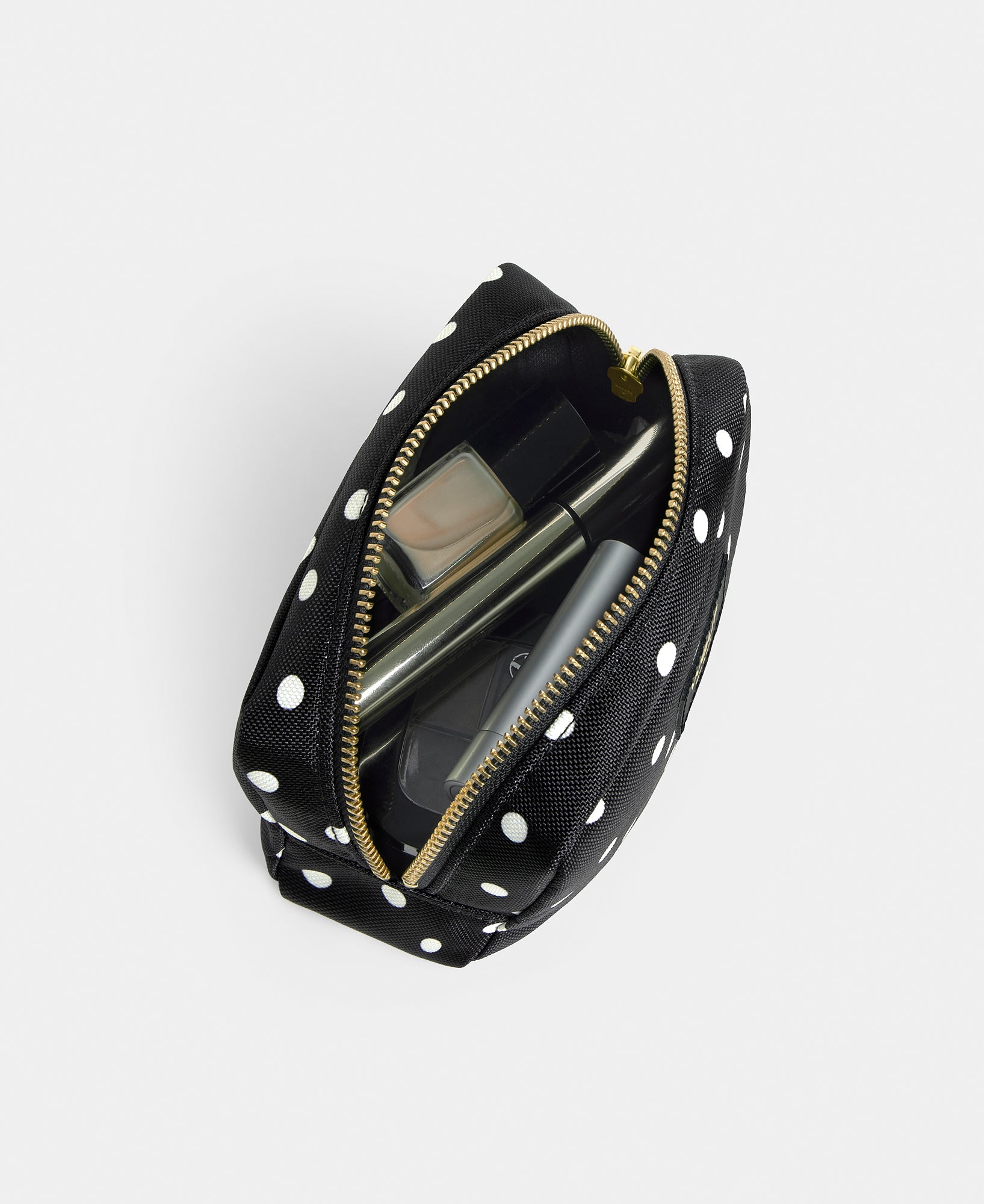 Interior detail of the Grace makeup bag with white polka dot print on a black background - Wouf