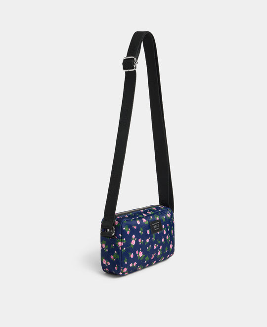 Vue latérale de le mini sac bandoulière Edith à imprimé floral rose et vert sur fond bleu marine - Wouf
