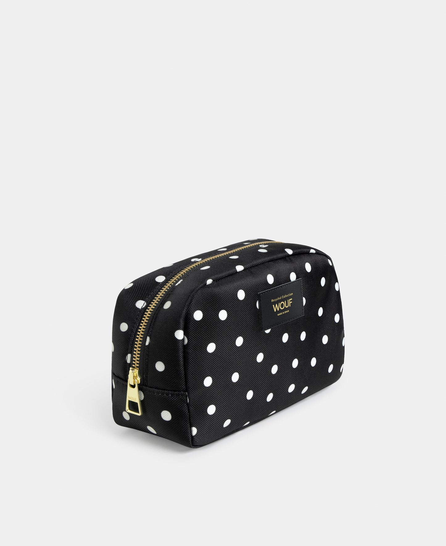 Side view of the Grace toiletry bag with white polka dot print on a black background - Wouf