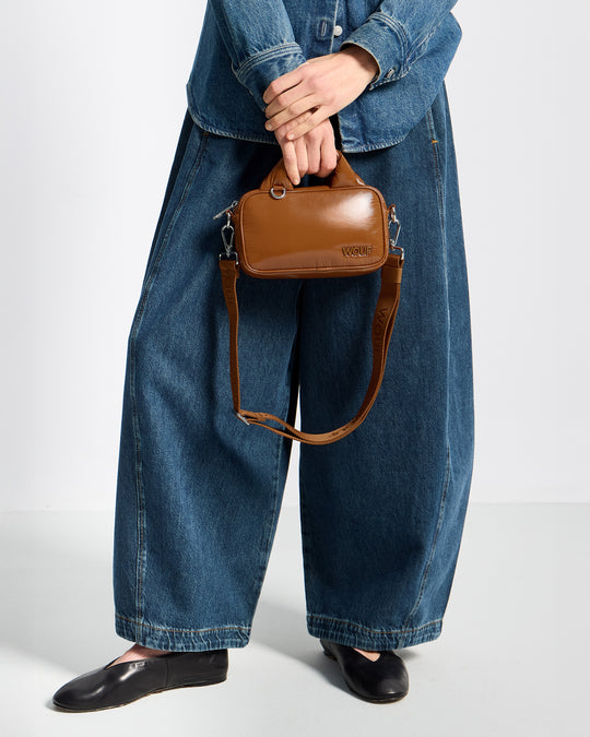 Detail of model with mini Bag toasted brown colour with a shiny finish - Wouf