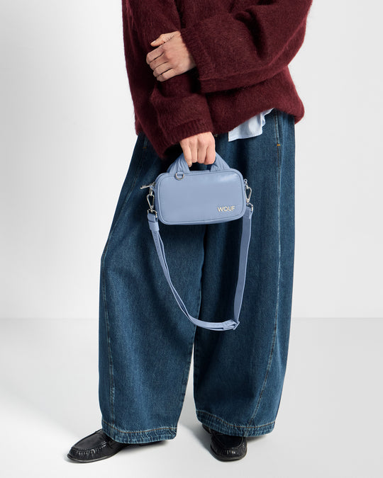 Detalle de modelo con mini Bag color azul acero con acabado brillante - Wouf