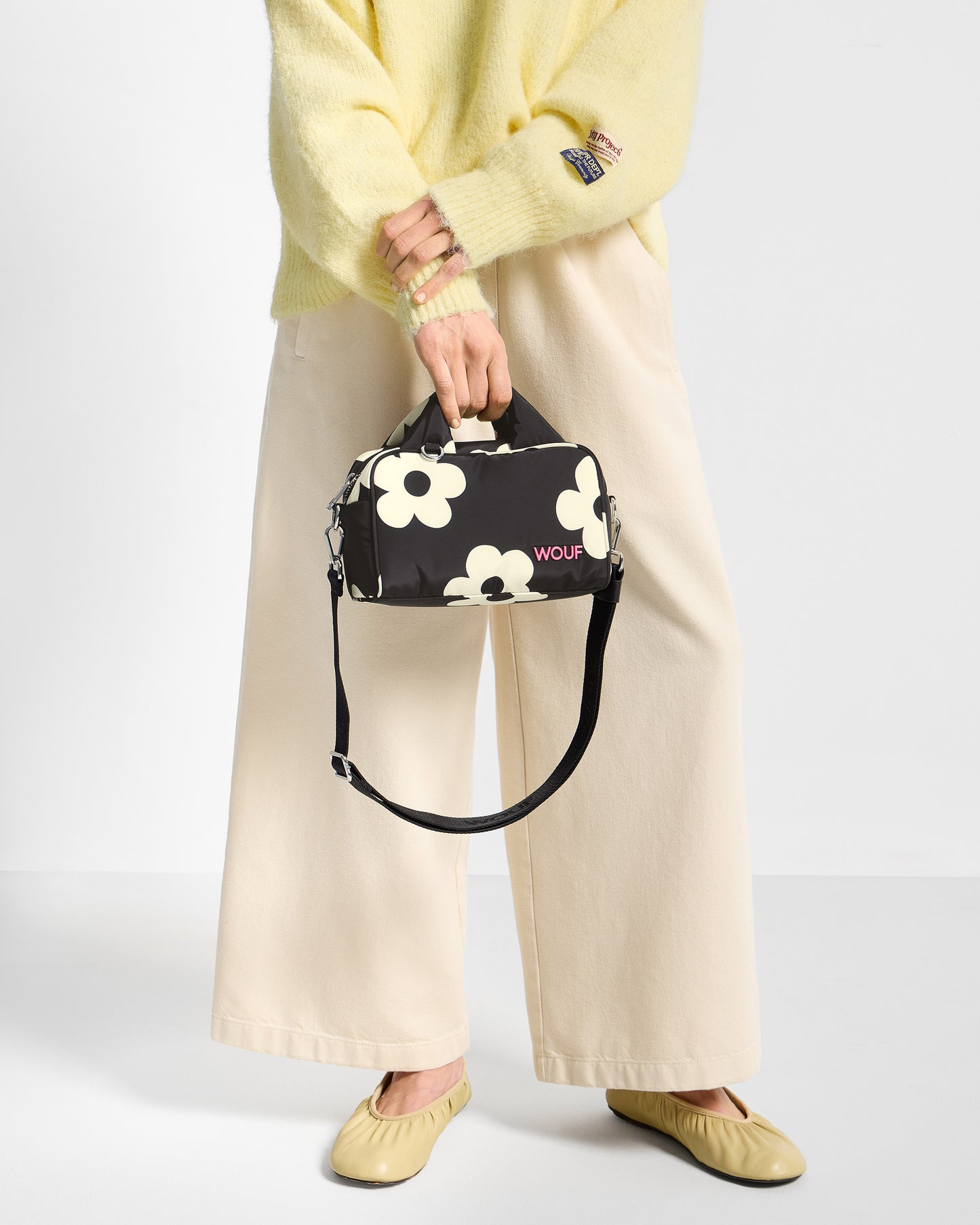 Detail of model with bowling bag with white floral print on a black background - Wouf