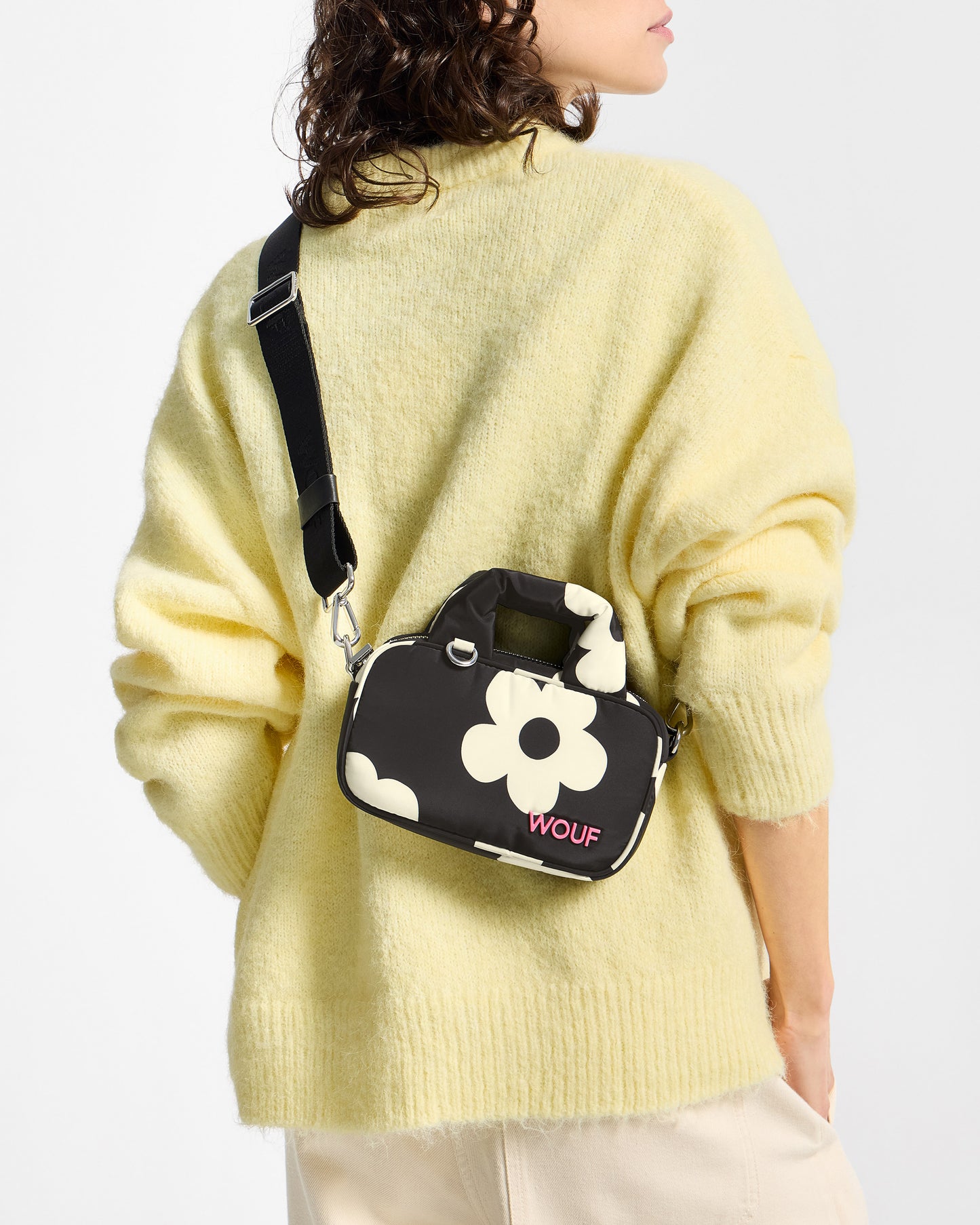 Détail de mannequin avec mini sac à imprimé floral blanc sur fond noir - Wouf