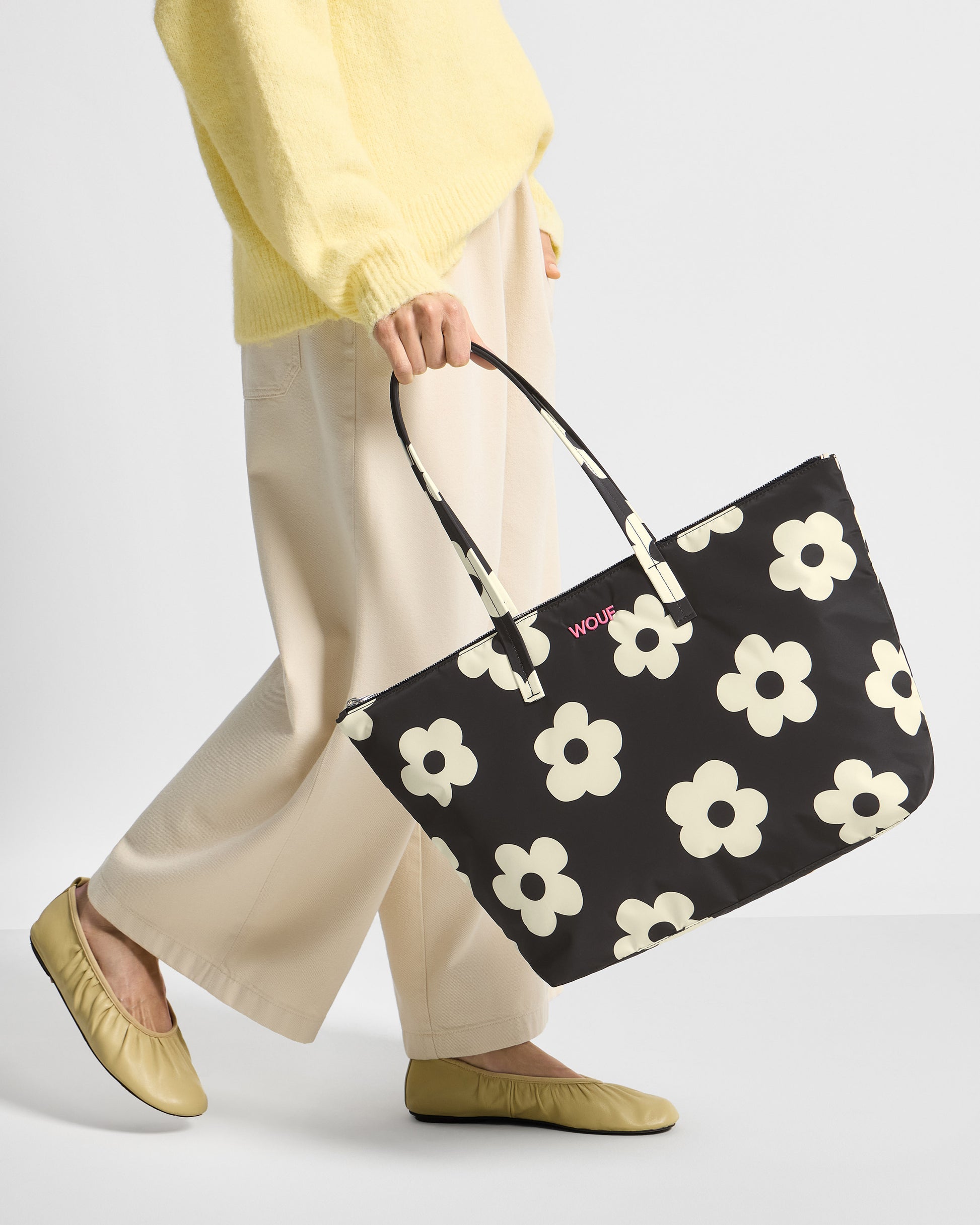 Detalle de modelo con bolso shopper con estampado floral blanco sobre fondo negro - Wouf