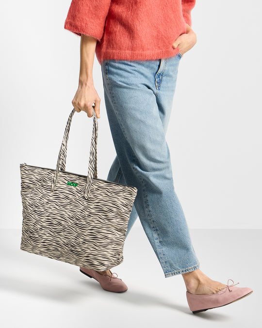 Détail de mannequin avec sac shopper à imprimé zèbre dans des tons beige et noir - Wouf