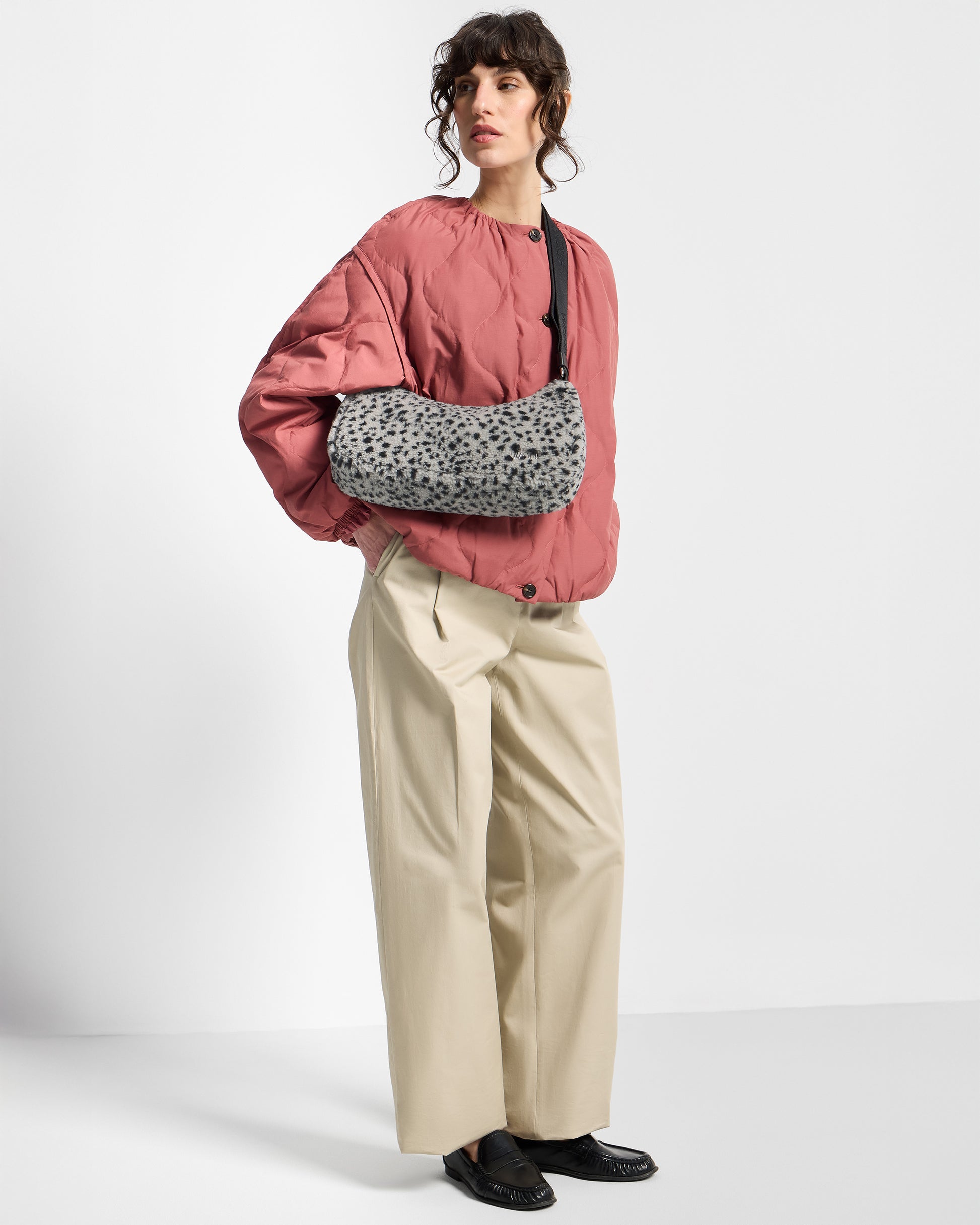 Model with crossbody bag in teddy fabric with black micro print on a grey background - Wouf