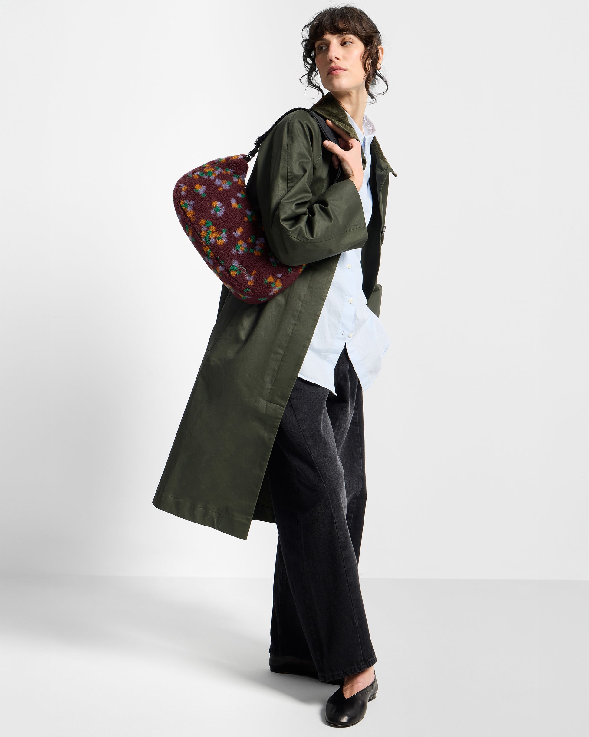 Model with crossbody bag in teddy fabric with multicolour floral print on a burgundy background - Wouf