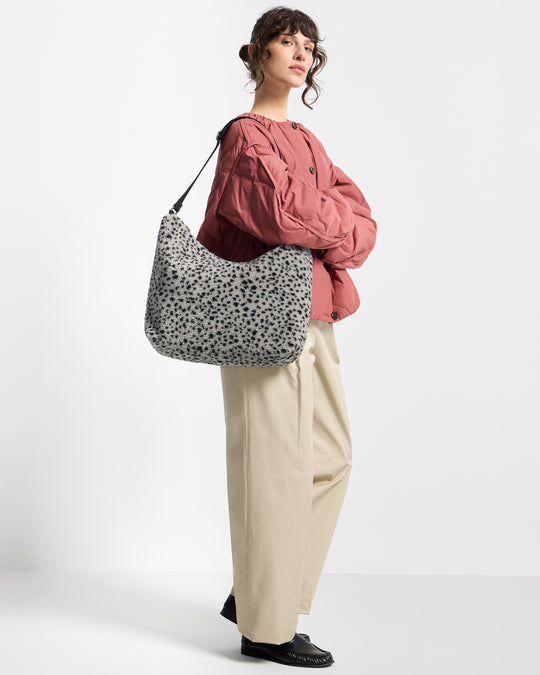 Modelo con bolso hobo de tejido teddy con micro estampado negro sobre fondo gris - Wouf