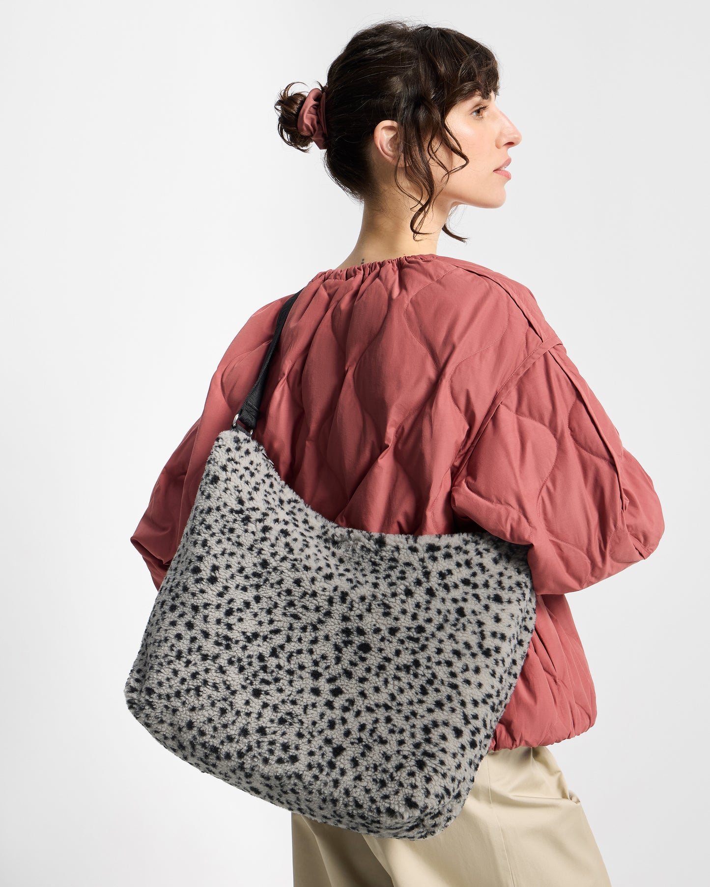 Detail of model with hobo bag in teddy fabric with black micro print on a grey background - Wouf