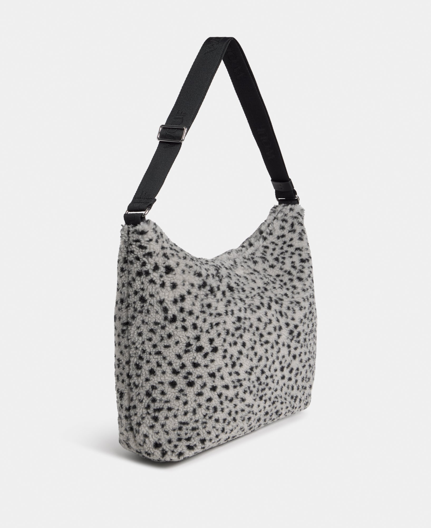 Side view of the hobo bag in teddy fabric with black micro print on a grey background - Wouf