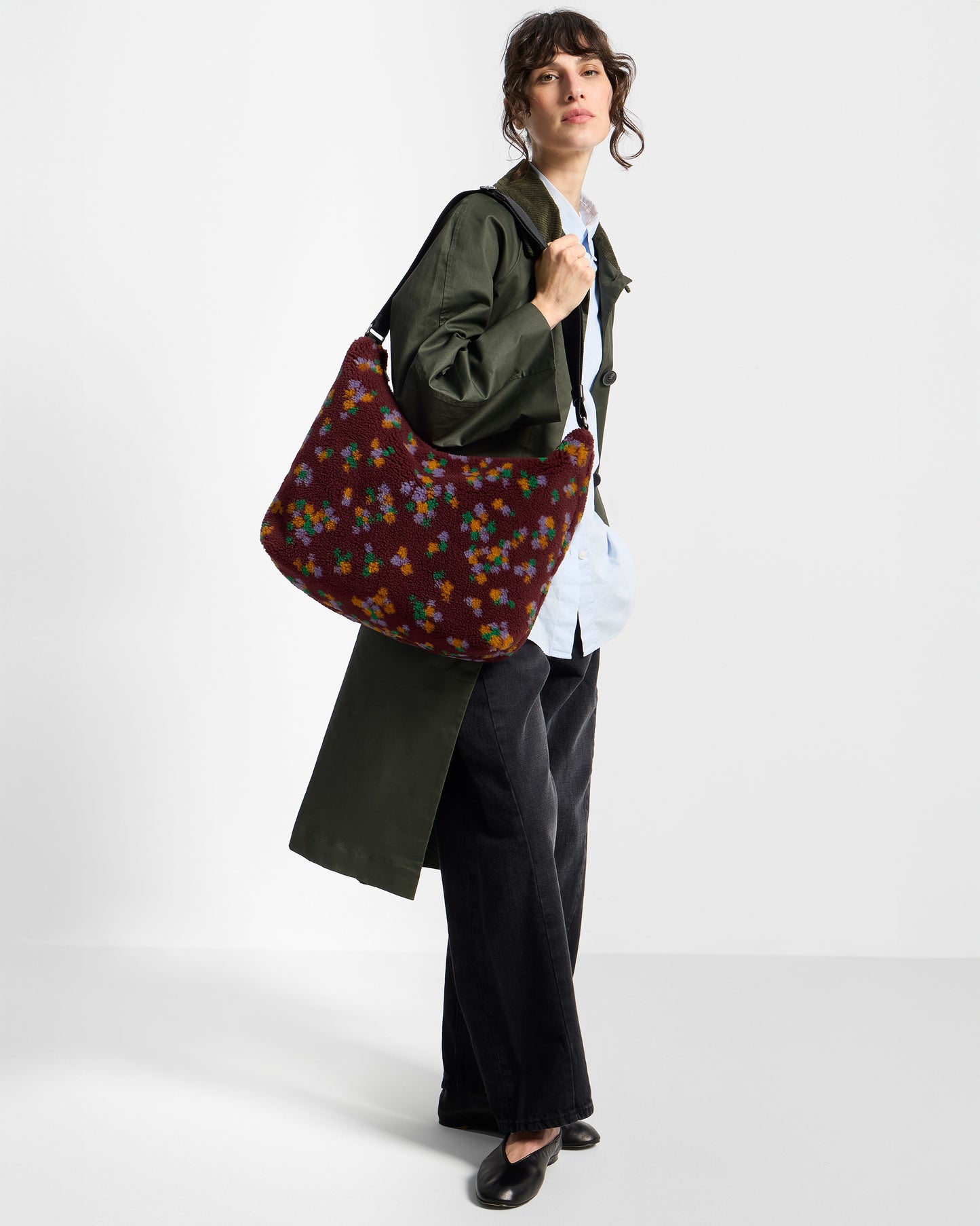 Modelo con bolso hobo de tejido teddy con estampado floral multicolor sobre fondo burdeos - Wouf