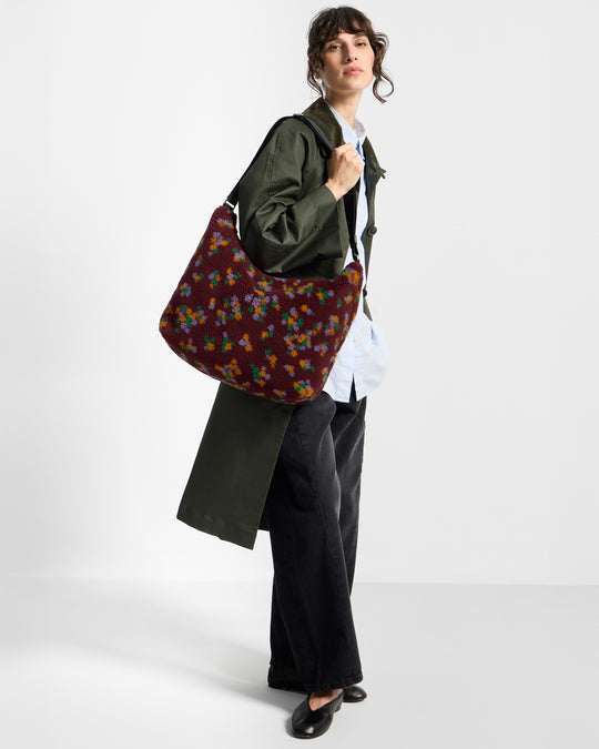 Modelo con bolso hobo de tejido teddy con estampado floral multicolor sobre fondo burdeos - Wouf