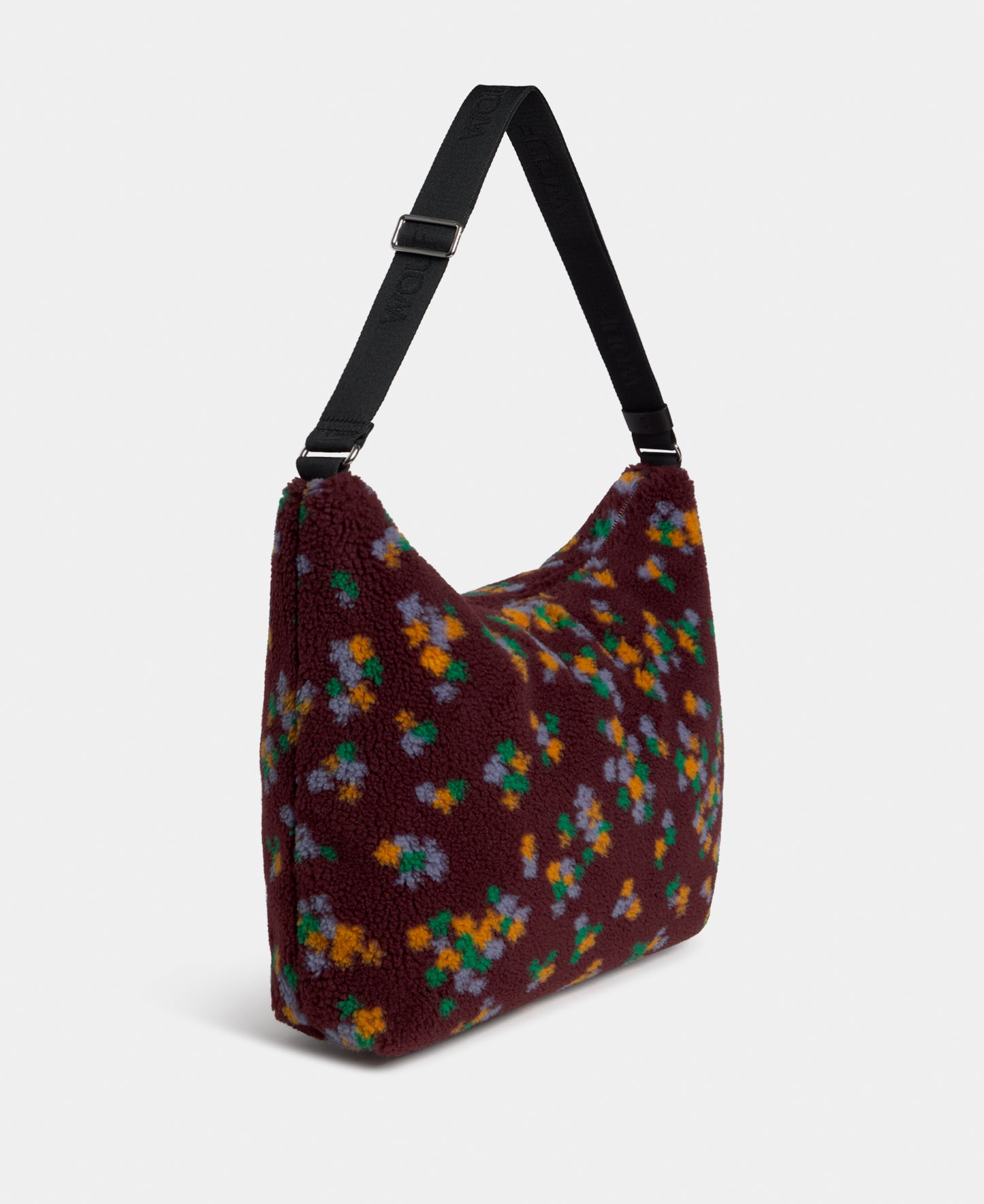 Side view of the hobo bag in teddy fabric with multicolour floral print on a burgundy background - Wouf