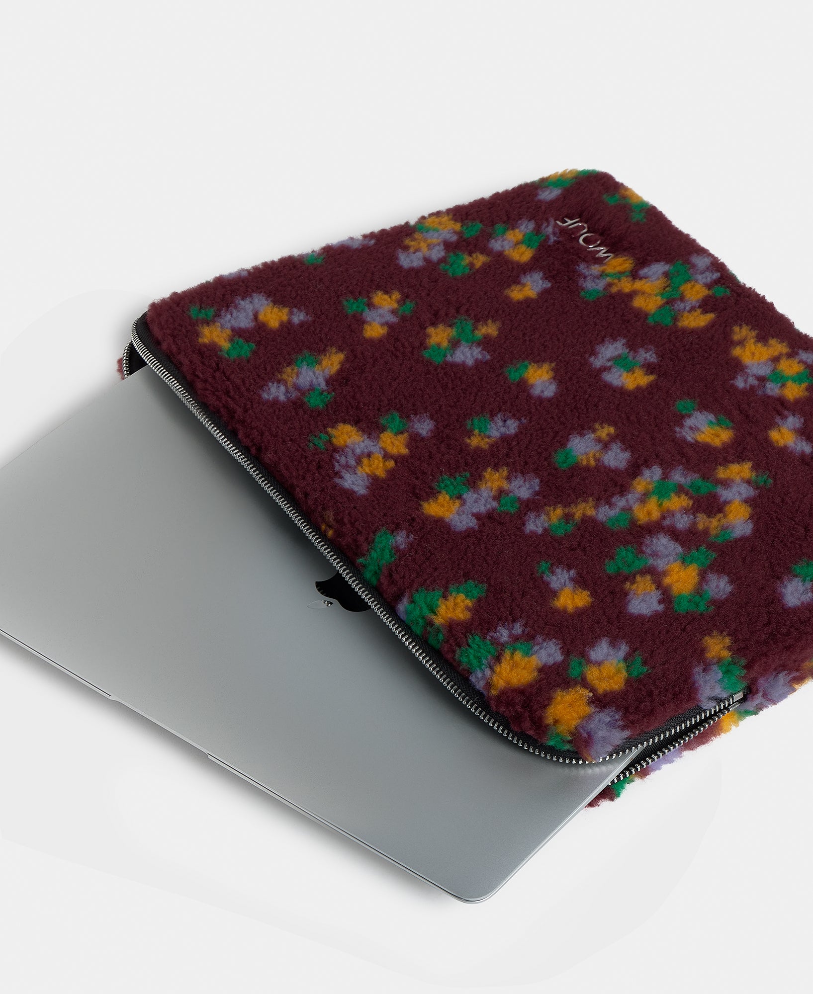 Detalle de la funda para portátil 13-14 de tejido teddy con estampado floral multicolor sobre fondo burdeos - Wouf