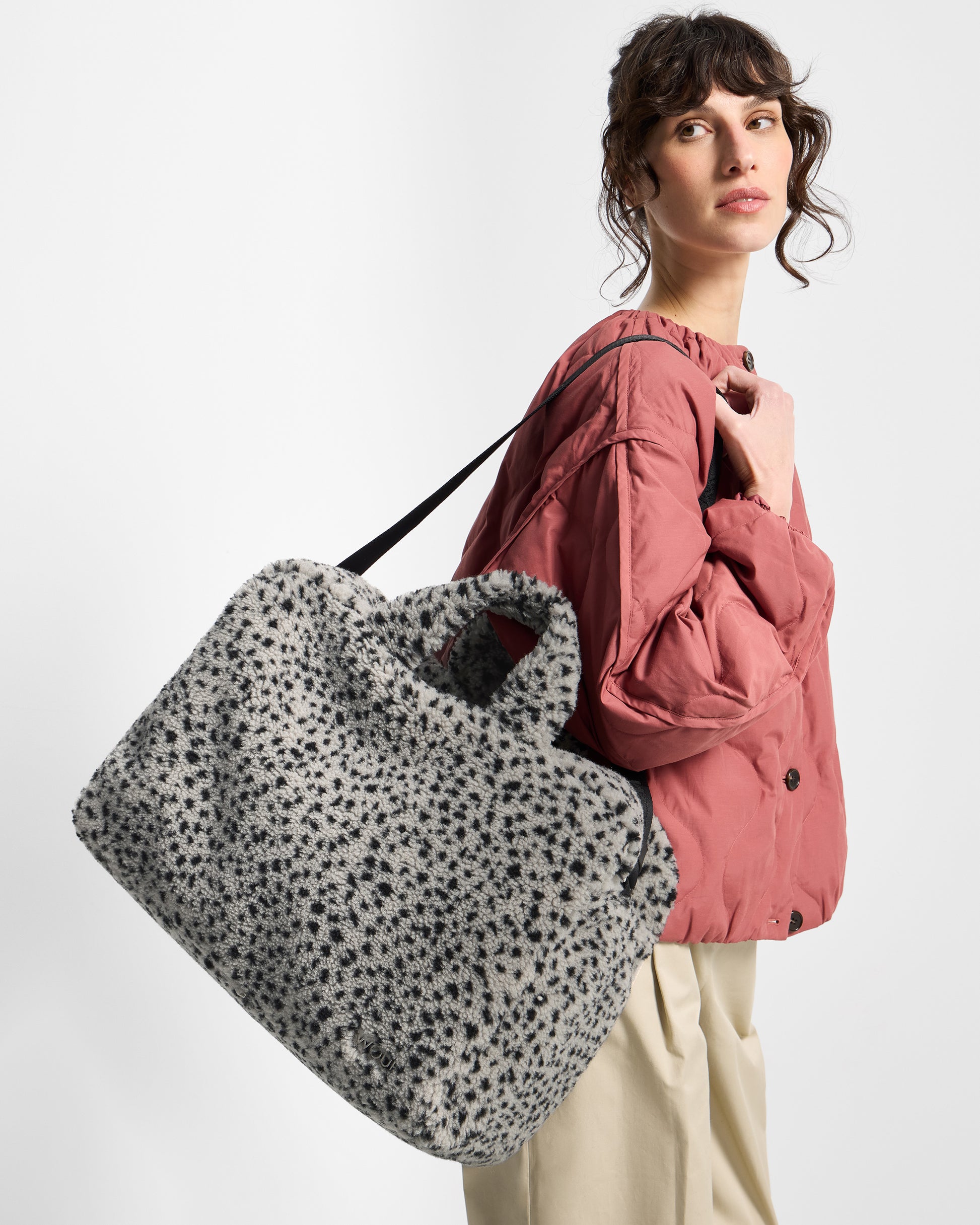 Detail of model with weekend bag in teddy fabric with black micro print on a grey background - Wouf