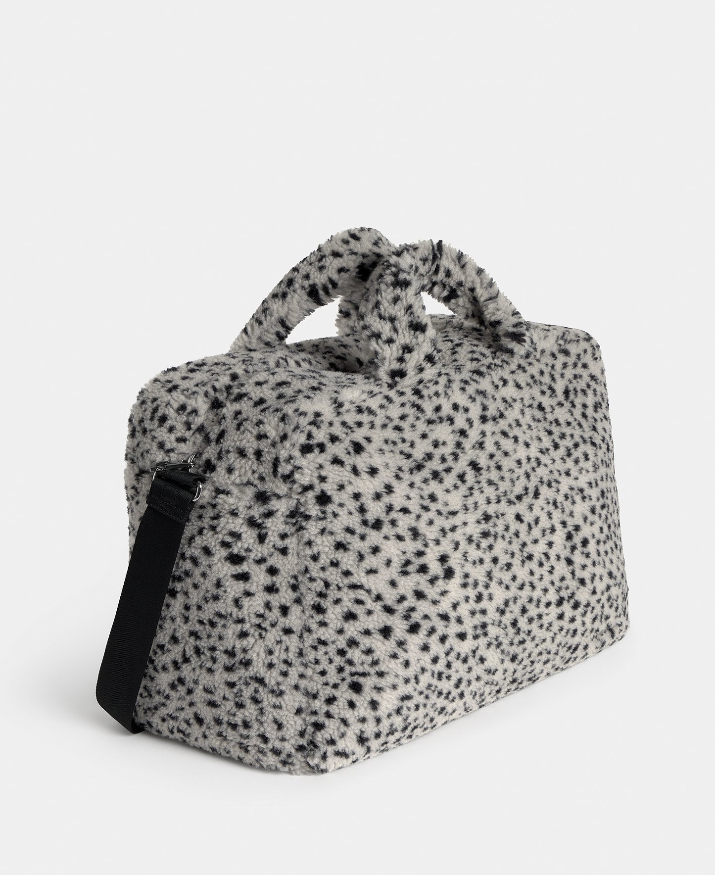 Side view of the weekend bag in teddy fabric with black micro print on a grey background - Wouf
