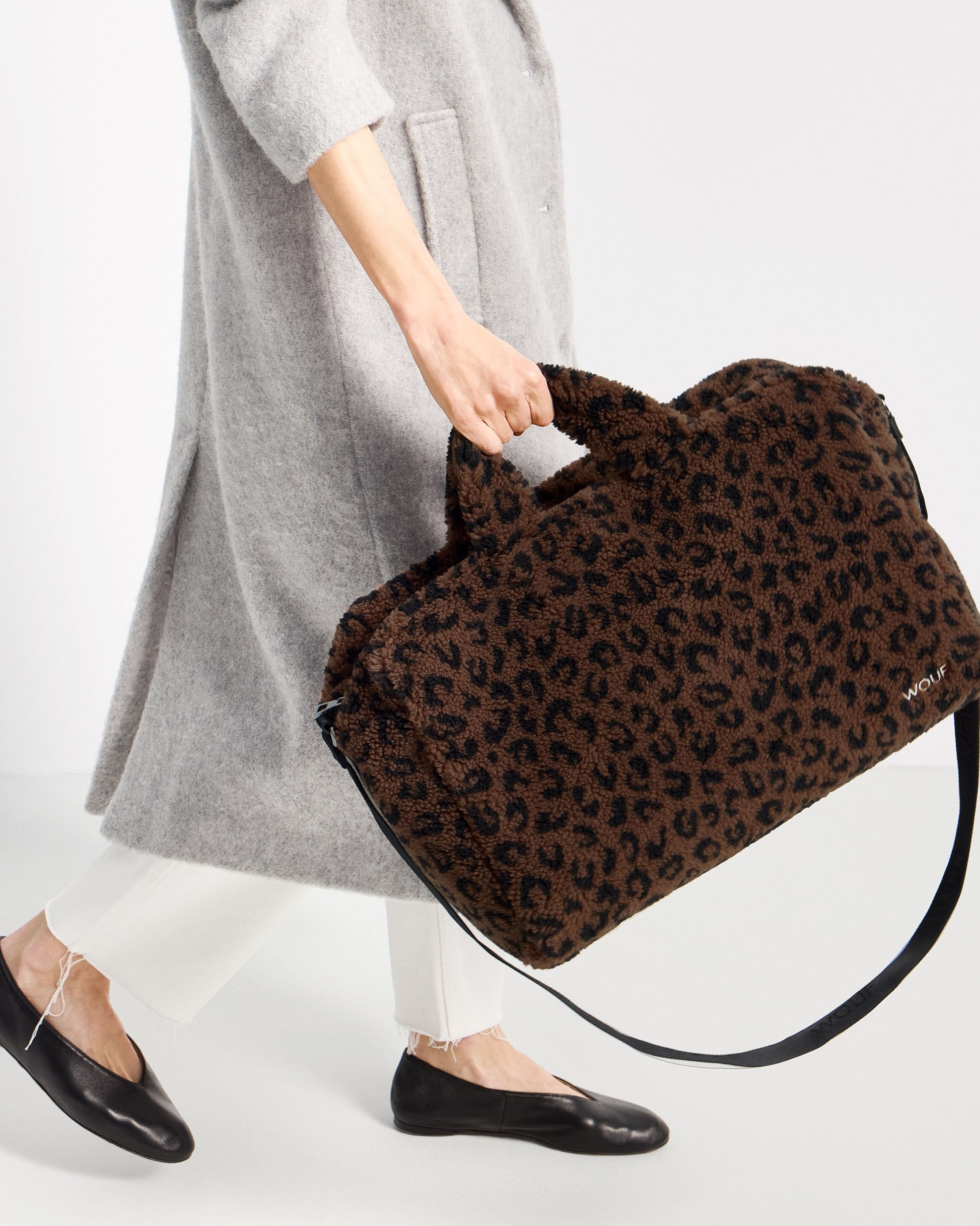 Detalle de modelo con bolso de fin de semana de tejido teddy con estampado de leopardo en tonos marrones y negros - Wouf